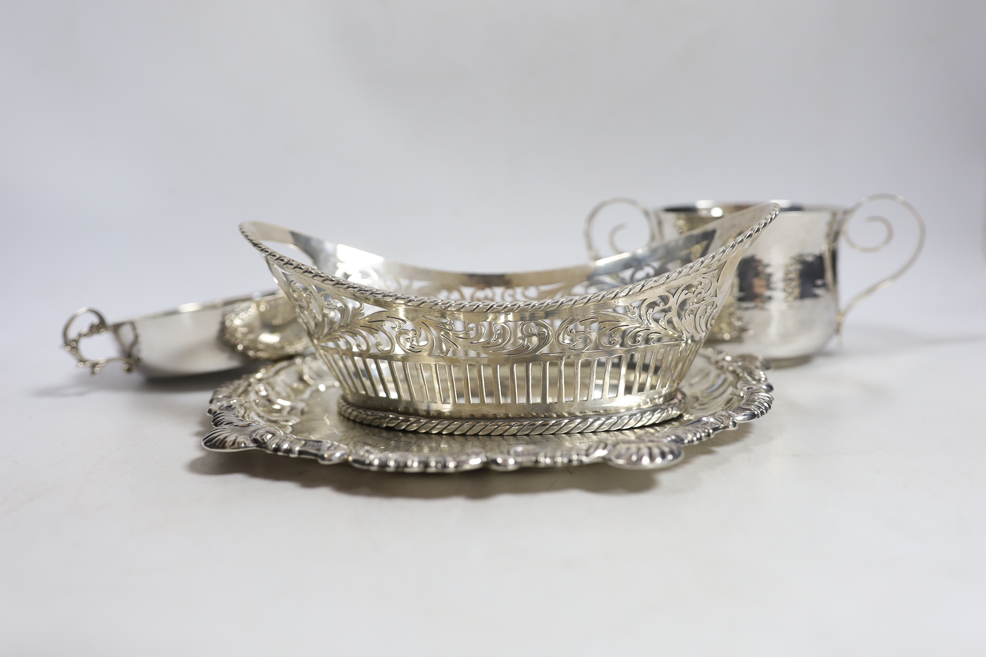 An Edwardian planished Britannia standard silver two handled cup, by Daniel & John Welby, London, 1902, height 77mm, together with a silver shallow two handled dish, a pierced silver oval dish and a silver waiter, 24.4oz